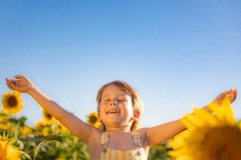 Happy child playing outdoor in spring field