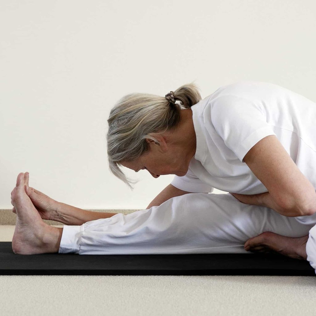 Deelnemer in een voorwaartse buiging, janu sirsasana