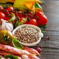 Uncooked mixed quinoa with vegetables on wood
